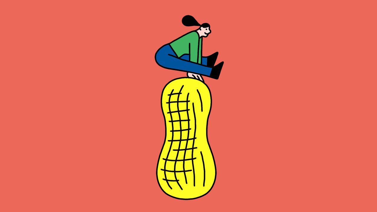 A person leaping over a large peanut